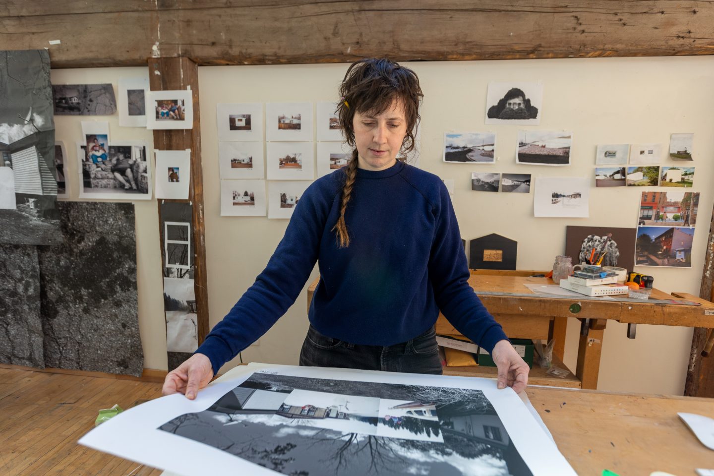 Woman examining prints of artwork that combine photography and digital media techniques in a workshop setting