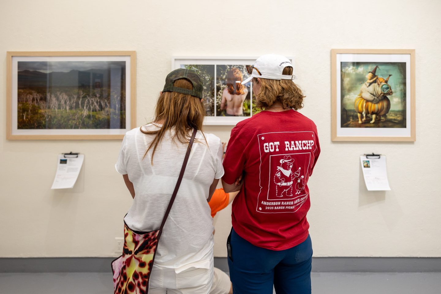 People in galley, looking at art.