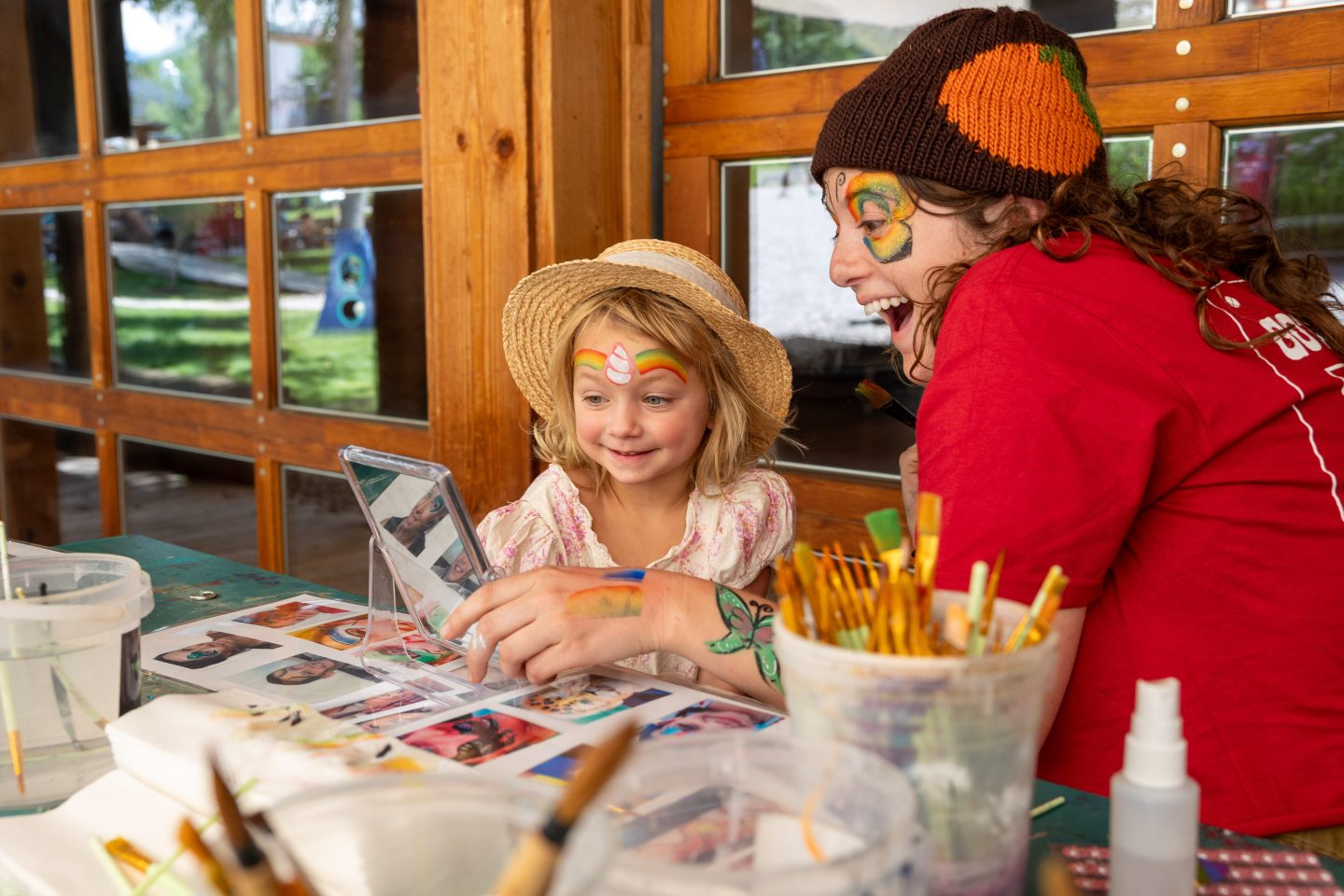 Girl looking at face paint in mirror.